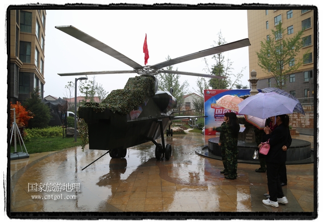 小區(qū)突然出現(xiàn)“飛機(jī)坦克”，其中殲15艦載戰(zhàn)斗機(jī)一架、99式主戰(zhàn)坦克一輛、武直-10武裝直升機(jī)一架，吸引了眾多市民雨中圍觀、合影。